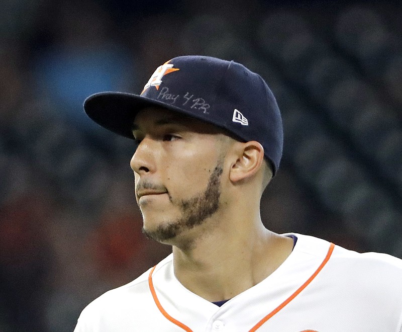 This is a Sept. 23, 2017, file photo showing Houston Astros shortstop Carlos Correa wears a message on his cap for those affected by the Hurricane in Puerto Rico during the second inning of a baseball game. Correa skipped the Astros' visit to the White House, Monday, March 12, 2018,  to help arrange for more relief supplies for shipment to hurricane-ravaged Puerto Rico, where he grew up. (AP Photo/David J. Phillip, File)