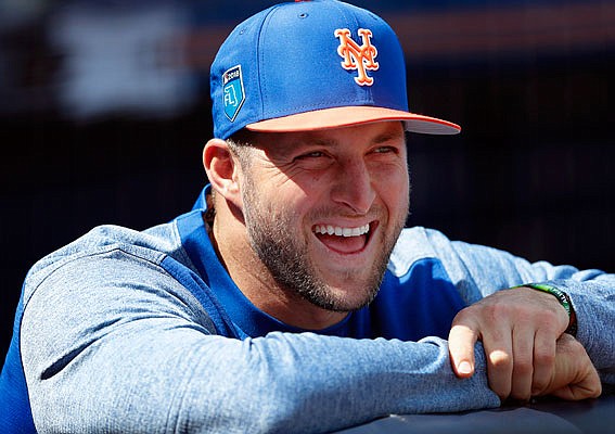 Tim Tebow laughs with his Mets teammates in the dugout before a spring training game against the Yankees last week in Port St. Lucie, Fla.