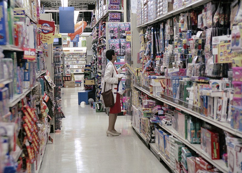 FILE- In this July 31, 1996, file photo, a shopper looks at toys in the old-style Toy "R" Us store in East Brunswick, N.J. Toys R Us CEO David Brandon told employees Wednesday, March 14, 2018, that the company's plan is to liquidate all of its U.S. stores, according to an audio recording of the meeting obtained by The Associated Press. (AP Photo/Daniel Hulshizer, File)