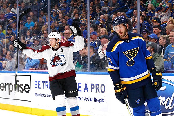 Nathan MacKinnon of the Avalanche celebrates after scoring a goal as Joel Edmundson of the Blues looks on during the first period of aThursday night's game in St. Louis.