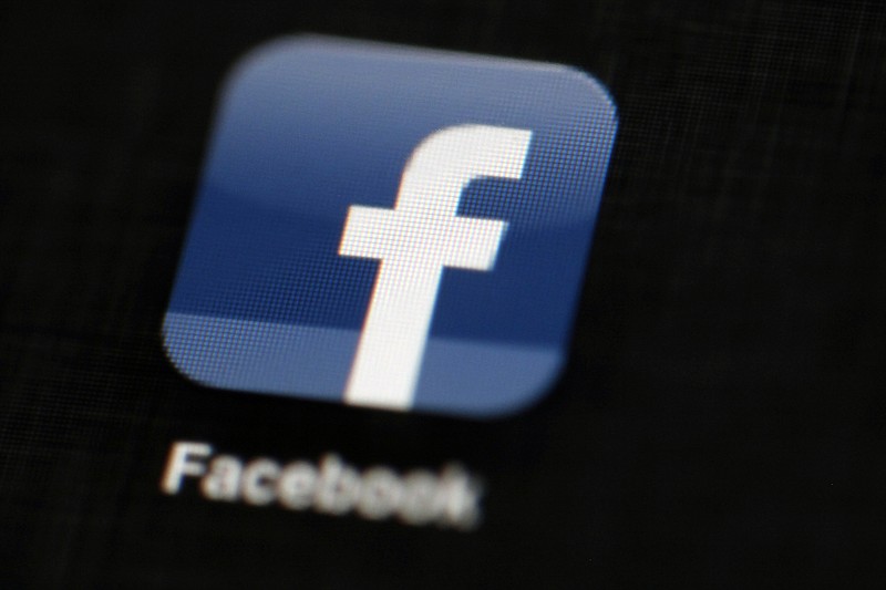 FILE - In this May 16, 2012, file photo, the Facebook logo is displayed on an iPad in Philadelphia.  Facebook suspended Cambridge Analytica, a data-analysis firm that worked for President Donald Trump's 2016 campaign, over allegations that it held onto improperly obtained user data after telling Facebook it had deleted the information.  (AP Photo/Matt Rourke, File)