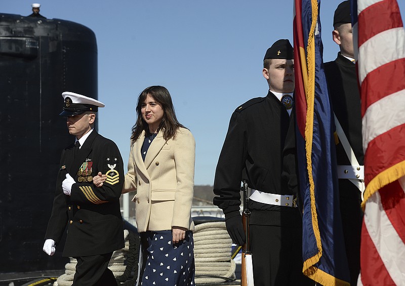 Ship's sponsor Annie Mabus, daughter of 75th Secretary of the Navy Ray Mabus, is escorted to the guests platform for the commissioning ceremony of the Virginia-class fast attack submarine USS Colorado (SSN 788) at Naval Submarine Base New London in Groton, Conn. Saturday, March 17, 2018. Mabus passes between the USS Colorado and the JROTC color guard from Wideview High School in Colorado Springs, Colo. on the way to the platform. (Dana Jensen/The Day via AP)