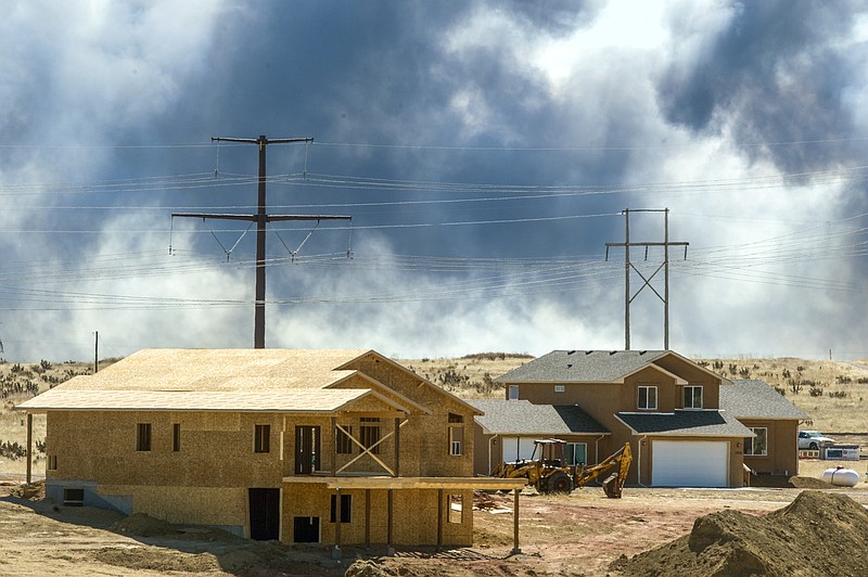 Smoke from a wildfire, named the Carson Midway wildfire, billows behind homes in Hanover, Colo., Friday March 16, 2018. (Dougal Brownlie/The Gazette via AP)