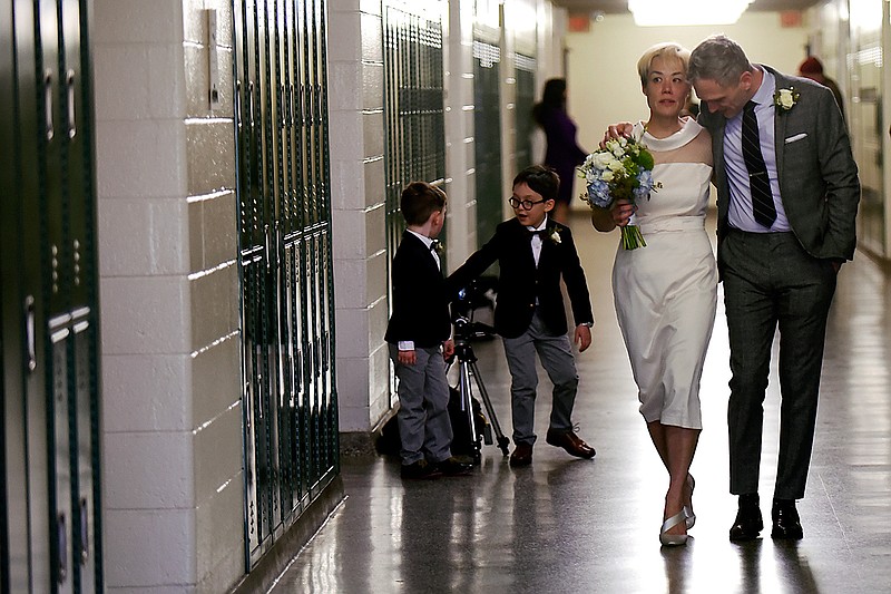 In this Saturday, March 10, 2018 photo, Jenn Sudol and Chris Gash walk near their old high school lockers during their wedding at Clifton High School, in Clifton, N.J. The couple met in 1989 when they were freshman at the school.  (Anne-Marie Caruso /The Record via AP)