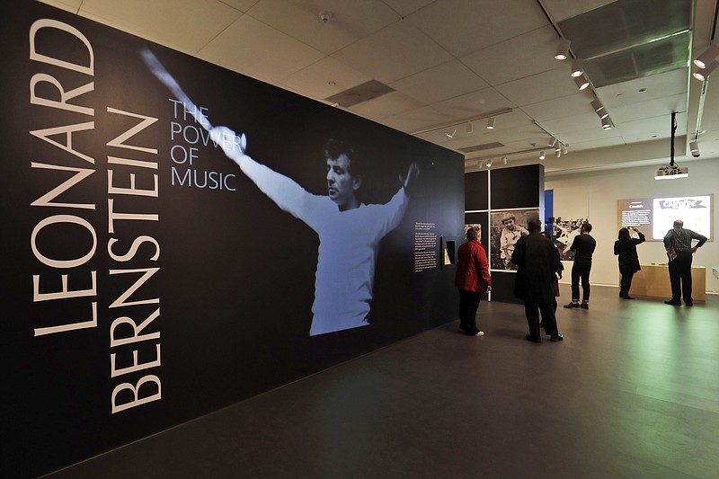 In this Wednesday, March 14, 2018 photo, journalists walk through the Leonard Bernstein exhibit during a press preview at the National Museum of American Jewish History in Philadelphia. The exhibit on the acclaimed composer and conductor opens March 16 and runs through Sept. 2, 2018. (AP Photo/Matt Slocum)