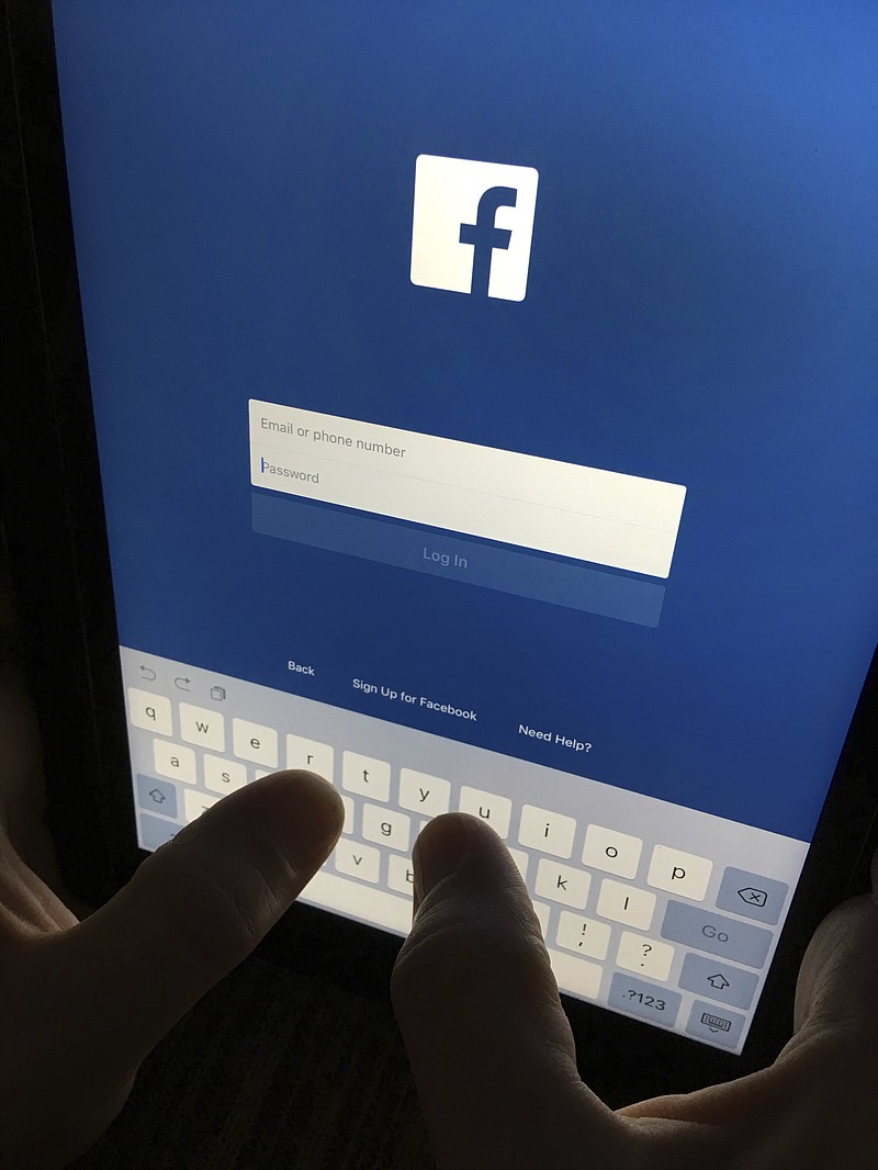FILE - This Monday, June 19, 2017, file photo shows a user signing in to Facebook on an iPad, in North Andover, Mass. Facebook has a problem it just can’t kick: People keep exploiting it in ways that could sway elections and even undermine democracy. (AP Photo/Elise Amendola, File)