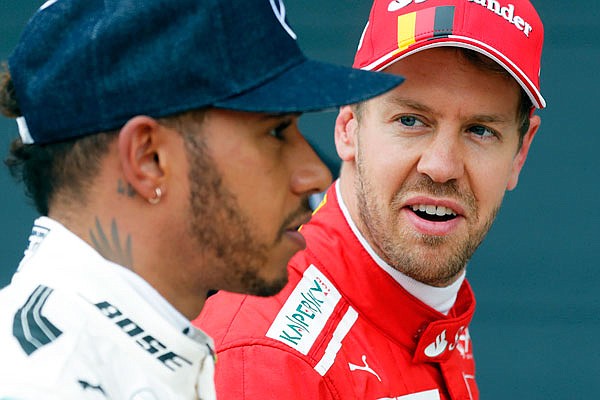 In this July 15, 2017, file photo, Sebastian Vettel looks at Lewis Hamilton after the qualifying session for the British Formula One Grand Prix in Silverstone, England. Hamilton and Vettel start the Formula One season attempting to win a fifth series championship.