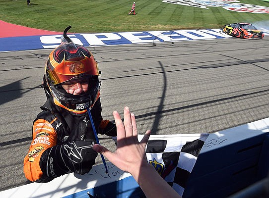 Martin Truex Jr. acknowledges Joel Cram, age 12, from Anna, Texas, after Joel gave Truex Jr. the checkered flag Sunday for winning the NASCAR Cup Series race in Fontana, Calif.