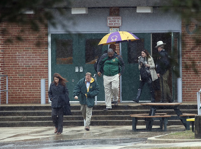 Teachers and school employees depart Great Mills High School, the scene of a shooting, Tuesday, March 20, 2018 in Great Mills, Md.  A teenager wounded a girl and a boy inside his Maryland high school Tuesday before an armed school resource officer was able to intervene, and each of them fired one more round as the shooter was fatally wounded, a sheriff said.  St. Mary's County Sheriff Tim Cameron said the student with the handgun was declared dead at a hospital, and the other two students were in critical condition. He said the officer was not harmed.  (AP Photo/Alex Brandon)