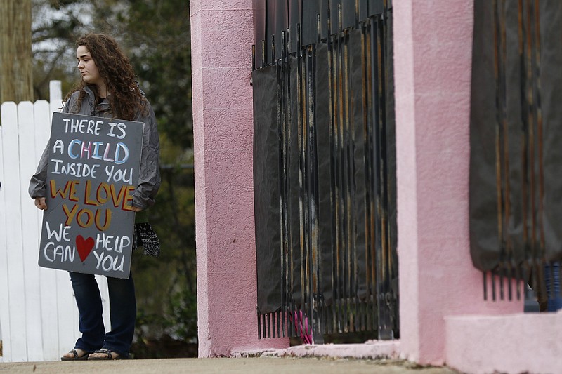 Lauren, an anti-abortion sidewalk counselor, stands outside the Jackson Women's Health Organization's clinic, the only facility in the state that performs abortions, Tuesday, March 20, 2018 in Jackson, Miss. A federal judge is temporarily blocking a new Mississippi law that bans abortion after 15 weeks, the most restrictive abortion law in the United States.(AP Photo/Rogelio V. Solis)