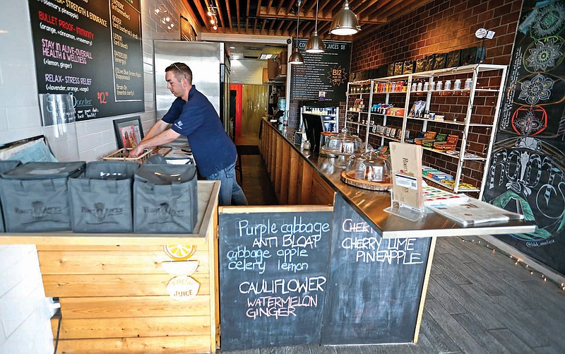 Matthew Holden works at Roots Juices in Dallas on Feb. 23. When the Dallas-based store began stocking its shelves with cannabis oil, its smoothie and juice shops in Oak Lawn and Lakewood attracted a loyal clientele and also some unwanted attention from law enforcement.