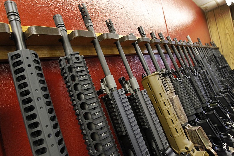 FILE - In this July 20, 2012, file photo, a row of different AR-15 style rifles are displayed for sale at the Firing-Line indoor range and gun shop in Aurora, Colo. A measure strengthening the federal background check system for gun purchases will be included in the $1.3 trillion government spending bill being negotiated by congressional leaders, aides say. The "Fix NICS" measure would provide funding for states to comply with the existing National Instant Criminal Background Check system and penalize federal agencies that don't comply. (AP Photo/Alex Brandon, File)