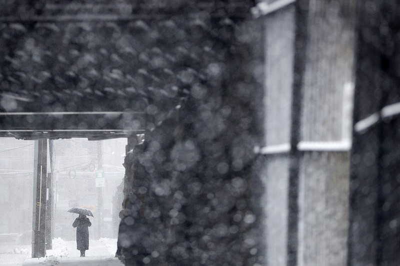 A woman uses an umbrella while shielding herself from a snowstorm, Wednesday, March 21, 2018, in Hoboken, N.J. A spring nor'easter targeted the Northeast on Wednesday with strong winds and a foot or more of snow expected in some parts of the region. (AP Photo/Julio Cortez)