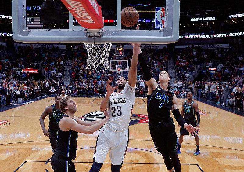 New Orleans Pelicans guard Ian Clark (23) goes to the basket between Dallas Mavericks' Dwight Powell (7) and Dirk Nowitzki during the first half of an NBA basketball game in New Orleans, Tuesday, March 20, 2018. (AP Photo/Gerald Herbert)