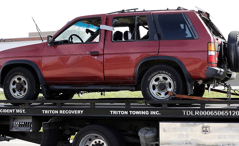 Officials remove the car belonging to Mark Anthony Conditt, the suspect in a series of bombing attacks in Austin who authorities say blew himself up Wednesday in Round Rock, Texas, after authorities closed in.