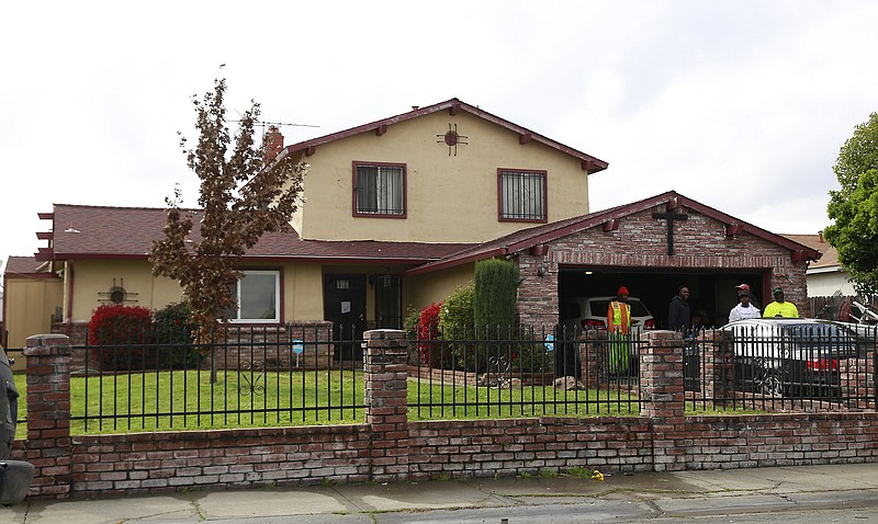 People gather outside the home, Wednesday March 21, 2018, where Stephon Alonzo Clark, 22, was shot and killed by a pair of Sacramento Police officers in Sacramento, Calif. The police said the two officers were responding to a call of a man breaking at least three vehicle windows Sunday night. Clark, who was unarmed, was shot in the backyard of his grandmother's home, where he was staying. Video footage released Wednesday shows the officers yelling that Clark had a gun before firing. No gun was found at the scene. (AP Photo/Rich Pedroncelli)