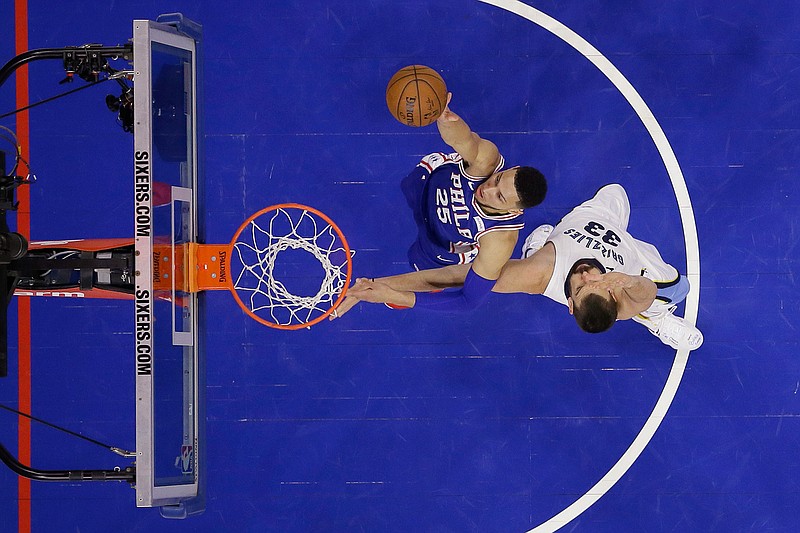 Philadelphia 76ers' Ben Simmons shoots next to Memphis Grizzlies' Marc Gasol during the first half of an NBA basketball game Wednesday in Philadelphia.