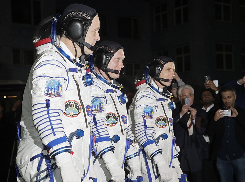 Russian cosmonaut Oleg Artemyev, center, and U.S. astronauts Richard Arnold, right, and Andrew Feustel, members of the main crew of the expedition to the International Space Station, walk Wednesday, March 21, 2018, to report to members of the State Committee prior the launch of Soyuz MS-08 space ship at the Russian leased Baikonur cosmodrome, Kazakhstan.