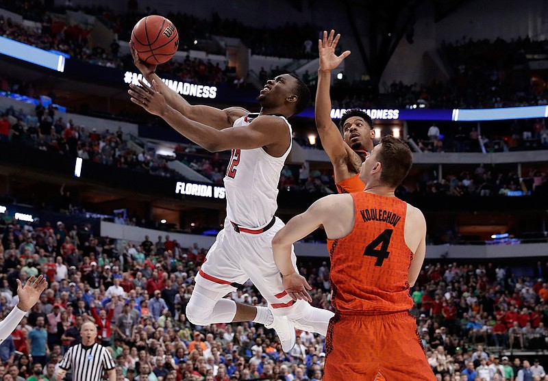 Texas Tech guard Keenan Evans (12) shoots after driving between Florida's Jalen Hudson, rear, and Egor Koulechov (4) during the second half of a second-round game in the NCAA men's college basketball tournament March 17 in Dallas. 