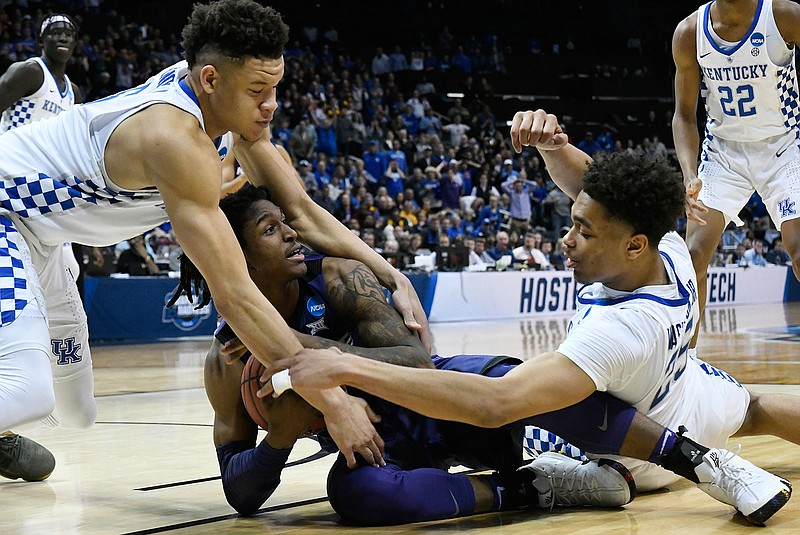 Kansas State guard Cartier Diarra (2) holds onto the ball as Kentucky's PJ Washington (25) and Kevin Knox (5) defend during the second half of a regional semifinal NCAA college basketball tournament game, Friday, March 23, 2018, in Atlanta. Kansas State won 61-58. (AP Photo/John Amis)