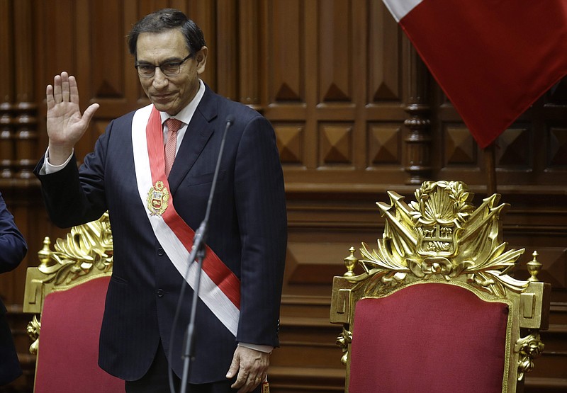 Peru's President Martin Vizcarra waves after he was sworn in to office taking over from his predecessor, Pedro Pablo Kuczynski, who has resigned over corruption allegations, in Lima, Peru, Friday, March 23, 2018. Vizcarra who became Peru's new president Friday has scarce experience governing but is known as a consensus builder who might have a shot at bridging divides after one of the worst political crises in the Andean nation's recent history. (AP Photo/Martin Mejia)