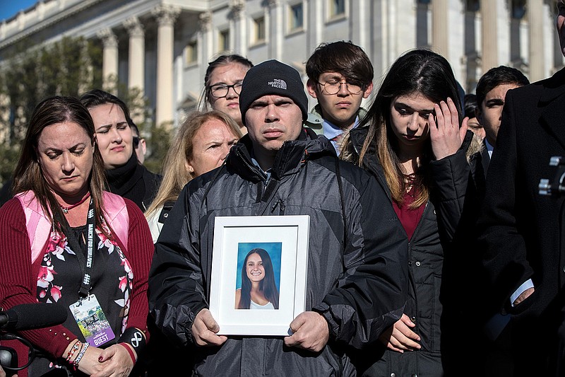 Ilan Alhadeff, joined at left by his wife Lori Alhadeff, holds a photograph of their daughter, Alyssa Alhadeff, 14, who was killed at Marjory Stoneman Douglas High School in Parkland, Fla., during a rally by lawmakers and student activists in support of gun control at the U.S. Capitol in Washington, Friday, March 23, 2018, a day before the March for Our Lives event. (AP Photo/J. Scott Applewhite)