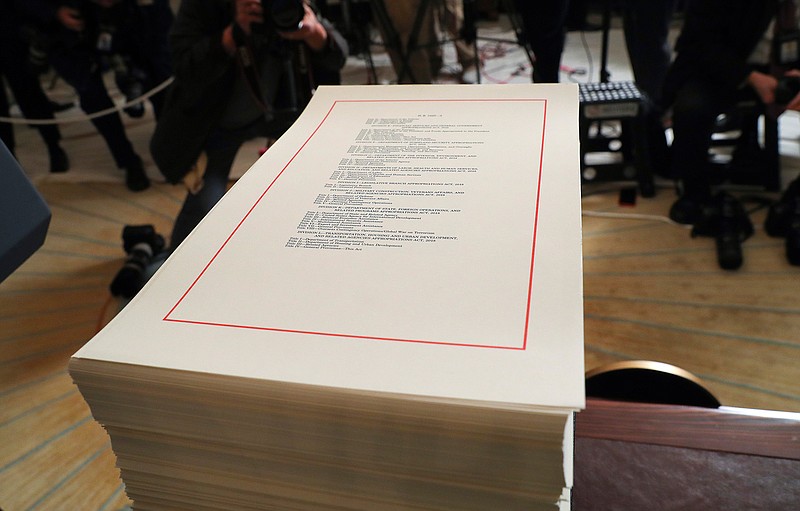 In this March 23, 2018, photo, a copy of the $1.3 trillion spending bill is stacked on a table in the Diplomatic Room of the White House in Washington. Under President Barack Obama and a GOP-controlled Congress, Capitol Hill Democrats had to scratch and claw for months to get tiny increases for domestic programs, but they got almost everything they wanted under a GOP Congress and President Donald Trump. (AP Photo/Pablo Martinez Monsivais)