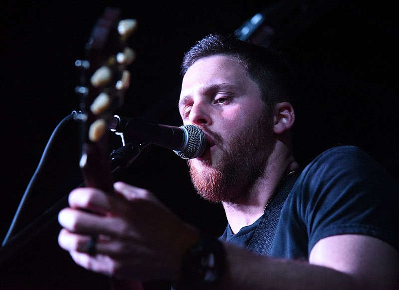 Josh Higgins focuses on executing a chord on his guitar whilst singing during a live performance at The Bridge as a part of the Battle for the Badges event on Saturday, March 24, 2018. Never Blue Avenue was one of three bands to perform on the day at The Bridge in Jefferson City.