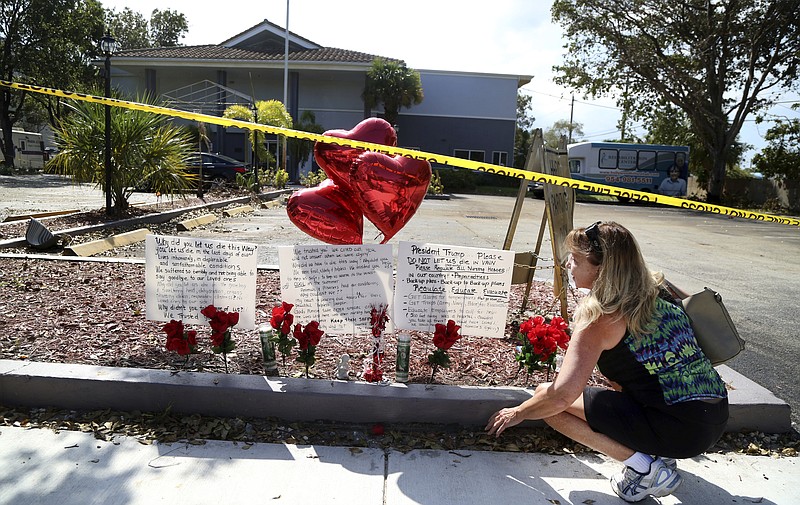 FILE - In this Sept. 14, 2017, file photo, Janice Connelly of Hollywood, Fla., sets up a makeshift memorial in memory of the senior citizens who died in the heat at the Rehabilitation Center at Hollywood Hills in Hollywood. Gov. Rick Scott signed legislation Monday, March 26, 2018, requiring backup power sources in Florida nursing homes and assisted living facilities, months after the deaths of several residents from a sweltering nursing home that lost power in a hurricane. (Carline Jean/South Florida Sun-Sentinel via AP, File)