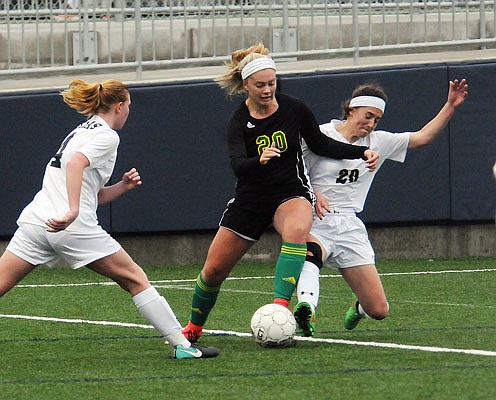 Helias teammates Grace Winegar (left) and Jennifer Szumigala sandwich Caroline Cole of Rock Bridge during Wednesday night's game at the Crusader Athletic Complex.