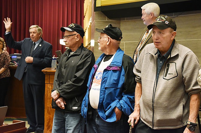 Lt. Gov. Mike Parson, background left, is recognized and thanked for his military service along with the more than 100 Vietnam veterans who made the trip to the Capitol on Thursday, including, from right, Ralph Simpson, Air Force; Joe Hoelscher, Army; and Bob Linnenbrink, Navy. The veterans were invited onto the floor of the Missouri House of Representatives to be recognized, one by one, and thanked for their service. 