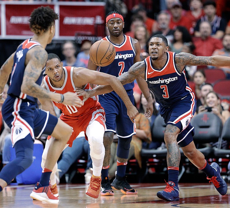 Houston Rockets guard Eric Gordon (10) and Washington Wizards guard Bradley Beal (3) chase a loose ball between Wizards forward Kelly Oubre Jr. (12) and guard John Wall (2) during the first half of an NBA basketball game Tuesday, April 3, 2018, in Houston. (AP Photo/Michael Wyke)