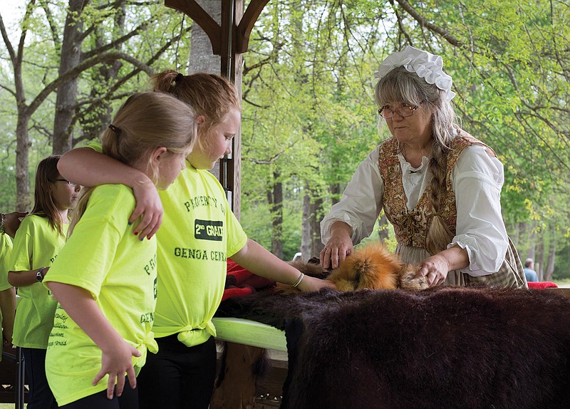 Debbie Chandler gives area students an idea of what life was like for a fur trader in the early 1800s. More than 500 students from area schools attended the first day of the three-day bicentennial celebration of the Sulphur Fork Factory that opened in 1818 near the confluence of the Sulphur and Red Rivers in Southeastern Miller County. The event, which continues today and Sunday, offers a glimpse into life at the American Indian trading post through displays and reenactors.  (Staff photo by Danielle Dupree)