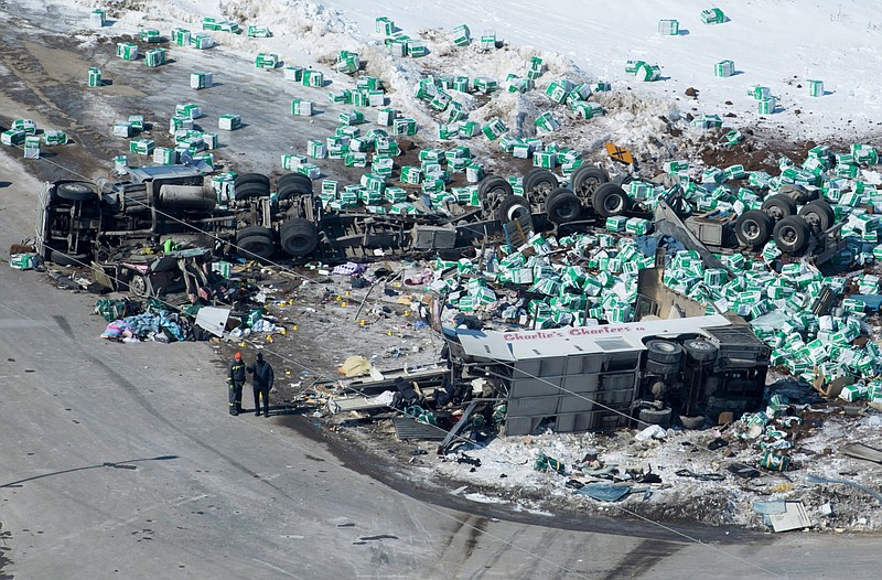 Emergency personnel work at the scene of a fatal crash outside of Tisdale, Saskatchewan, Canada, Saturday, April, 7, 2018. A bus en route to Nipawin, foreground, carrying the Humboldt Broncos junior hockey team crashed into a truck Friday night, killing 14 and sending over a dozen more to the hospital.(Jonathan Hayward/The Canadian Press via AP)