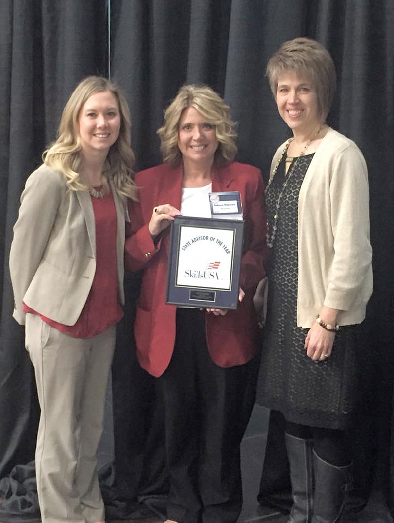 Eldon High School placement counselor Erin Rohwer, left, and Eldon Career Center Director Kelli Engelbrecht, right, pose with SkillsUSA Advisor of the Year Becky Dickerson, center, as she holds her plaque. 