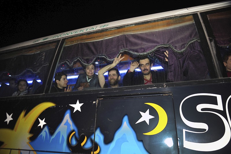 In this photo released by the Syrian official news agency SANA, shows a bus carrying civilians who were released by the Army of Islam group that were held them since 2013, in Damascus, Syria, early Monday, April 9, 2018. Syrian state media is reporting that dozens of civilians who had been held for years by a rebel group near the capital Damascus have been freed. (SANA via AP)