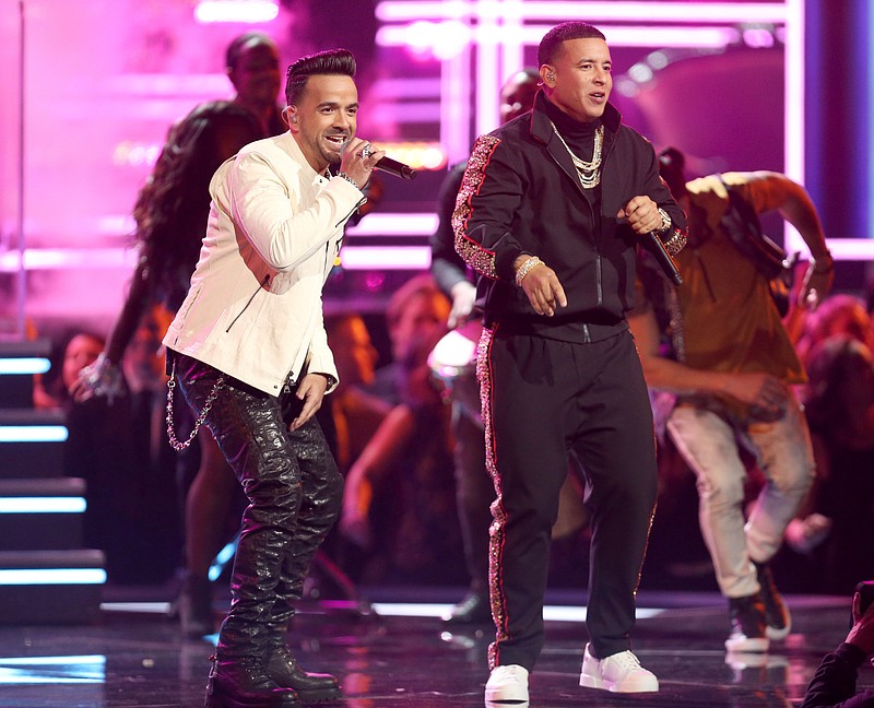 FILE - In this Jan. 28, 2018 file photo, Luis Fonsi, left, and Daddy Yankee perform "Despacito" at the 60th annual Grammy Awards in New York. “Despacito” and other popular music videos were the target of a security breach on the video sharing service Vevo. The cover image of the Luis Fonsi/Daddy Yankee hit was replaced by an image of masked people pointing guns. Clips by Taylor Swift, Drake, Selena Gomez and Shakira also were affected. A YouTube spokesperson says the company worked with its partner to disable access after seeing “unusual upload activity” on some Vevo channels. (Photo by Matt Sayles/Invision/AP, File)
