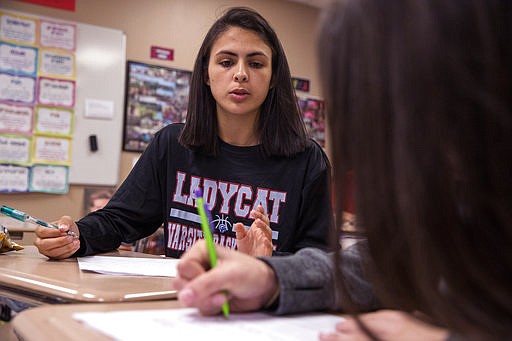 In this In this March 21, 2018 photo, Jessica Hernandez left, 16, and Chloe Rodriguez 16, work on an assignment in their English class at Gregory-Portland High School  in Portland, Texas.  Jessica, her mother, sister and two dogs moved to Portland, a town of about 16,000, after Hurricane Harvey damaged the apartment complex where they lived beyond repair. (Rachel Denny Clow/Corpus Christi Caller-Times via AP)