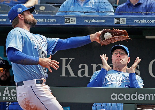 Royals first baseman Lucas Duda catches a foul ball near the dugout as Royals pitching coach Cal Eldred gets out of the way during the fourth inning of Wednesday afternoon's game at Kauffman Stadium.