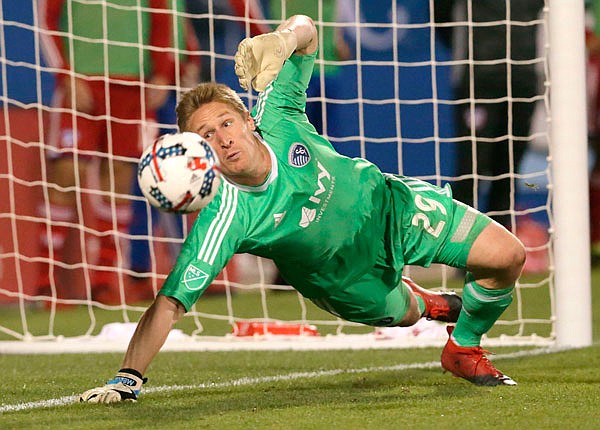 In this April 22, 2017, file photo, Sporting Kansas City goalkeeper Tim Melia dives in an attempt to make a save during the second half of a match against FC Dallas in Frisco, Texas.