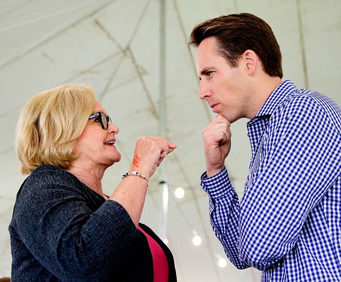 FILE - In this Aug. 17, 2017, file photo, Democratic U.S. Sen. Claire McCaskill, left, talks with Republican Missouri Attorney General Josh Hawley in Sedalia, Mo. Missouri Democrats are using Republican Gov. Eric Greitens' political and legal woes to try to attack Hawley, the top GOP candidate in a hotly contested U.S. Senate race. Democrats are seeking to tie Hawley to Greitens while Hawley is vying for Sen. Claire McCaskill's seat.