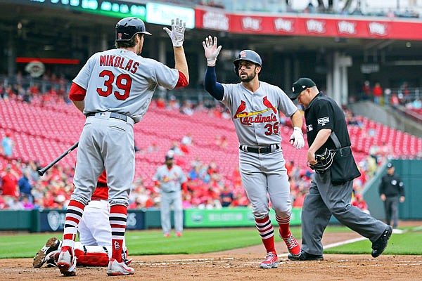 Greg Garcia high-fives Cardinals teammate Miles Mikolas after hitting a home run in the second inning of Saturday afternoon's game against the Reds in Cincinnati.