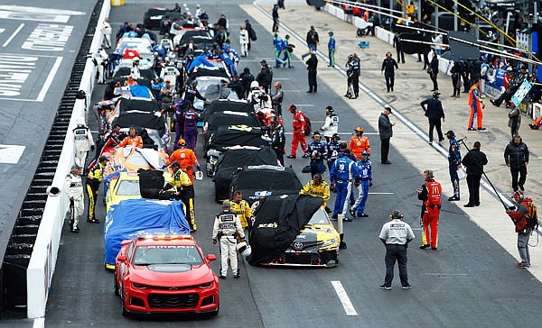 Crews cover their cars as a rain delay is called during the NASCAR Cup Series race Sunday in Bristol, Tenn.