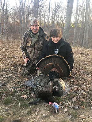 Bruce Sassmann and Callen Taylor pose with the turkey Callen took at Bruce's Prairie Star Restoration Farms.