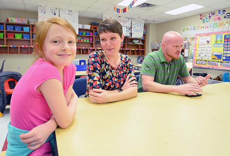Ava Roberts, 8, and her mom and dad, Emily and Mark, speak with a reporter Tuesday at Belair Elementary School about the rare condition the father and daughter have, which causes tumors to grow on organs.