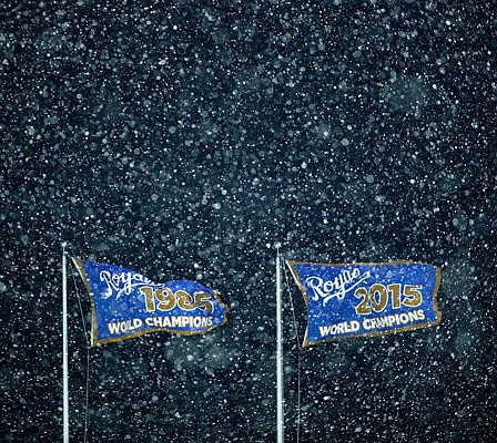 World championship flags fly as snow falls during the eighth inning of Saturday night's game between the Royals and the Angels at Kauffman Stadium.