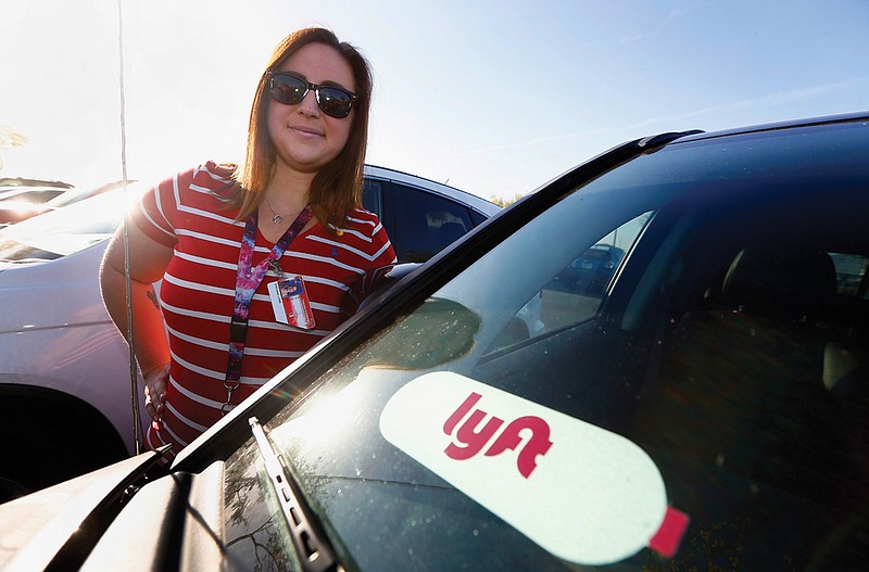  Stefanie Lowe, an elementary schoolteacher, stands next to her car after a "walk-in" for higher pay and school funding in Phoenix. 