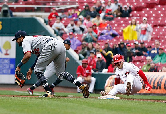 Tucker Barnhart of the Reds falls to the ground after colliding with Cardinals first baseman Jose Martinez during the ninth inning of Sunday's game in Cincinnati.