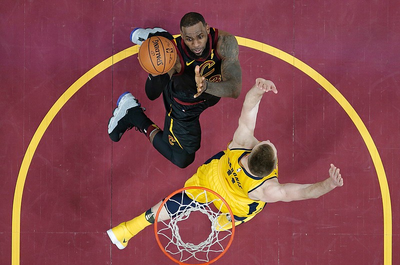 Cleveland Cavaliers' LeBron James, top, drives against Indiana Pacers' Domantas Sabonis in the first half of Game 1 of an NBA first-round playoff series Sunday in Cleveland.