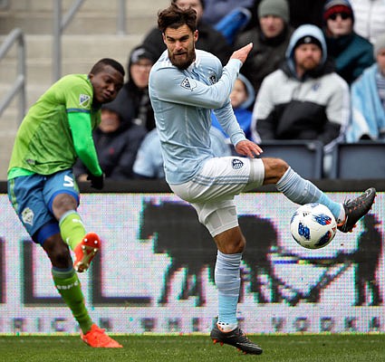 Sporting Kansas City midfielder Graham Zusi (right) blocks a kick by Seattle Sounders defender Nouhou Tolo during the first half of Sunday afternoon's MLS match in Kansas City, Kan.